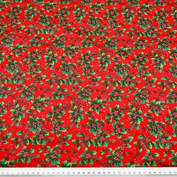 Patterned cotton satin with green holly on a red background