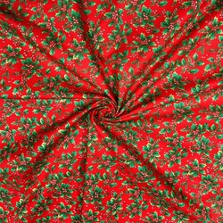 Patterned cotton satin with green holly on a red background