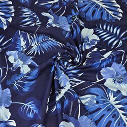 Cotton leaves with blue hibiscus flower on navy background